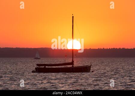 Auswanderer, traditional wooden sailing boat in Steinhuder Meer / Lake Steinhude silhouetted against sunset, Lower Saxony / Niedersachsen, Germany Stock Photo