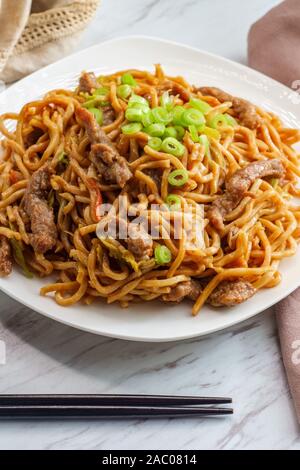 Eating Chinese beef lo mein noodles with chopsticks Stock Photo