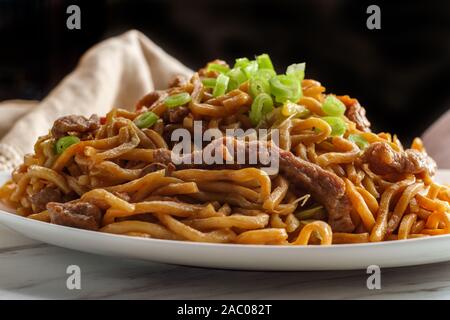 Eating Chinese beef lo mein noodles with chopsticks Stock Photo