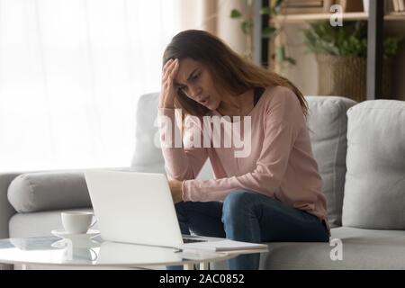 Frustrated girl look at laptop screen having operational problems Stock Photo