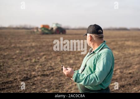 Modern senior farmer using tablet on the field Stock Photo