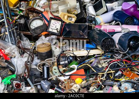 Old defective electrical appliances, parts, miscellaneous wires for sale in the market Stock Photo