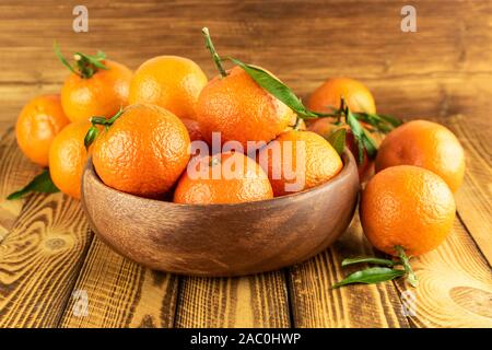 organic mandarin fruit in wooden bowl on wooden table Stock Photo