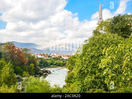 The river Neretva flows by the ancient wall surrounding the old town section of Mostar, Bosnia Stock Photo