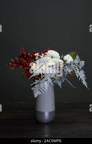 Christmas and New Year composition bouquet in a ceramic vase on a dark background, selective focus Stock Photo