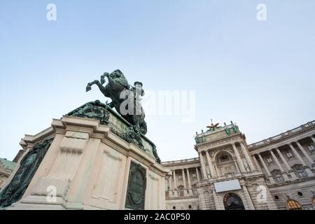 Hofburg palace, on its Neue Burg aisle, taken from the Heldenplatz square, with the 19th century Prinz Eugen statue in front in Vienna, Austria. It is Stock Photo