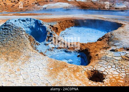 Mudpots in the geothermal area Hverir, Iceland. The area around the boiling mud is multicolored and cracked. Stock Photo