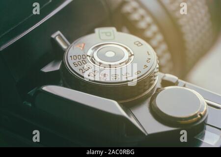Close-up of mode and shutter speed dial of a vintage retro photo film camera with orange light leak Stock Photo
