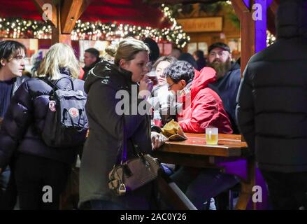 Berlin, Germany. 29th Nov, 2019. A visitor drinks mulled wine at the Christmas market in Berlin, Germany, on Nov. 29, 2019. Credit: Shan Yuqi/Xinhua/Alamy Live News Stock Photo