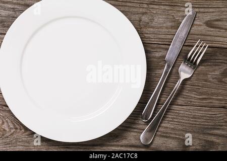 Empty plate and cutlery on a wooden table with copy space, top view. Food background Stock Photo