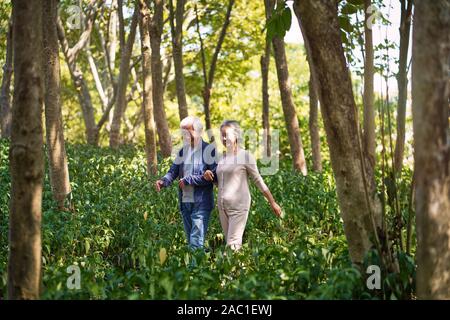 happy senior couple walking talking chatting relaxing in woods Stock Photo