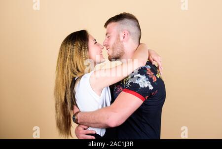 Couple flirting. Couple goals concept. Man and woman beige background. Family love. Romantic kiss. Trust and support. Cute and sweet relationship is dream for every girl in world. Couple in love. Stock Photo