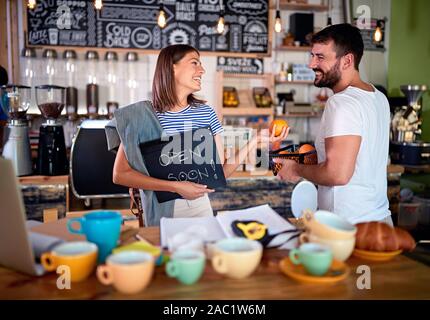 Man and woman are smiling because they are opening soon their business Stock Photo