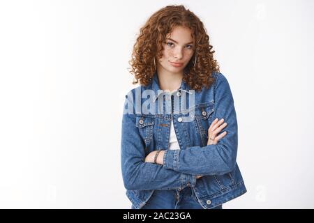 Spoiled young redhead daughter with curly hair freckles pimples acting silly childish pouting folding lips unsatisfied cross arms chest defensive pose Stock Photo