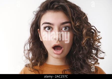 Headshot shocked speechless impressed attractive curly-haired caucasian woman drop jaw open mouth stunned gasping surprised cannot believe own eyes Stock Photo