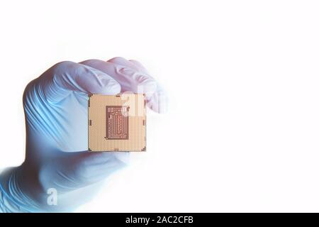 Close-up of hand in blue gloves holds micro processor cpu on white background. Stock Photo