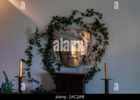 Capri, Italy - August 13, 2019: Stone face with wreath and candle in sunset light in villa san michele Stock Photo