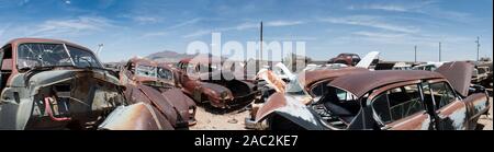 panorama showing Rows of vintage rusty cars and trucks in a desert junk yard near Phoenix Arizona USA Stock Photo