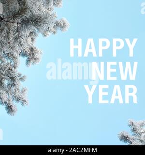 Happy New Year words winter square aspect ratio orientation on the blue colors sky. Snow covered frozen pine tree Stock Photo
