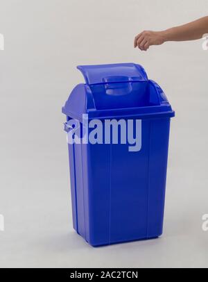 woman hand throwing something into the trash can isolated on white background Stock Photo