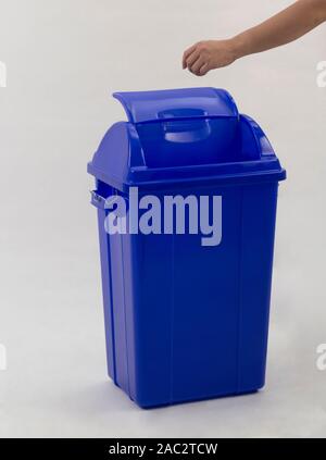 woman hand throwing something into the trash can isolated on white background Stock Photo