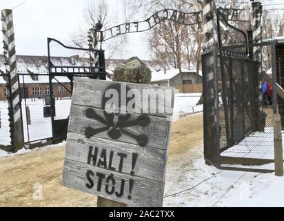 Oswiecim, Poland. 30th Nov, 2019. A view on the sign 'Halt' ('Stop') near the entrance to the Auschwitz I German Nazi concentration and extermination camp, with the motto 'Arbeit macht frei' ('Work brings freedom') over the main gateway.In two months, the 75th anniversary of the liberation of Auschwitz. The biggest German Nazi concentration and extermination camp KL Auschwitz-Birkenau was liberated by the Red Army on 27 January 1945. Credit: Damian Klamka/ZUMA Wire/Alamy Live News Stock Photo