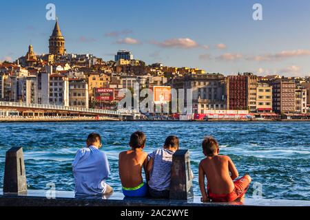 29 August 2019; Golden Horn, Istanbul, Turkey; Young boys preparing themselves to swim in the Turkish strait opposite to the Galata Tower. Stock Photo