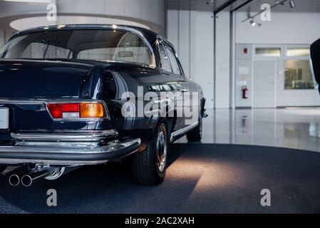 Back view of rare stylish automobile standing on the stand with lighting coming from above Stock Photo