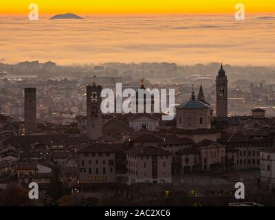 Bergamo, one of the most beautiful city in Italy. Amazing landscape at the old town during the sunrise. The fog covers the plain around the town Stock Photo