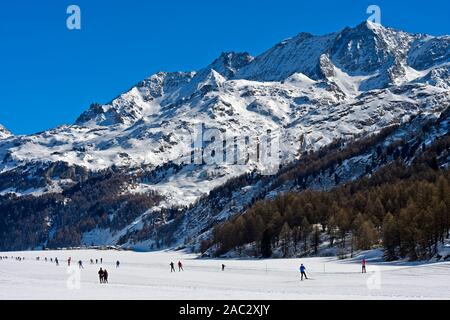 Cross-country trails on the frozen Lake Sils, cross-country center Maloja, Engadin, Grisons, Switzerland Stock Photo