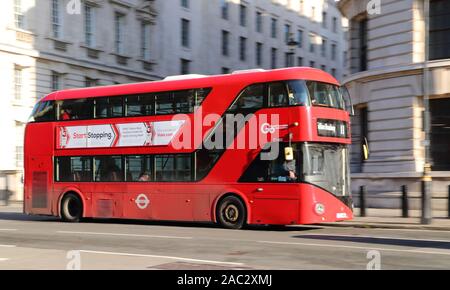 A typical red London Double-Decker bus driving along Whitehall in London, UK