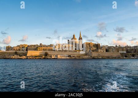 Panoramic view of Valletta Skyline at beautiful sunset from Sliema with churches of Our Lady of Mount Carmel and St. Paul's Anglican Pro-Cathedral, Va Stock Photo