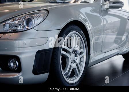 Left front part of brand new modern silver automobile. Partical view Stock Photo