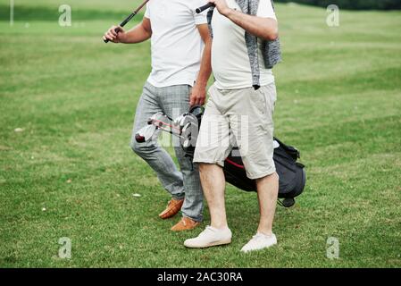 Cropped photo of two friends on the sports field with golf equipment Stock Photo