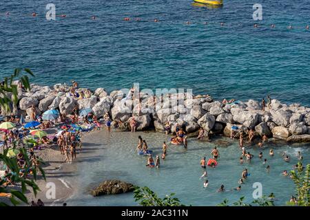 Capri, italy - August 13, 2019: Tourists enjoy beach time near Marina Grande harbour Stock Photo
