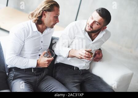 Two teammates have conversation in the break time and drinking some whiskey Stock Photo