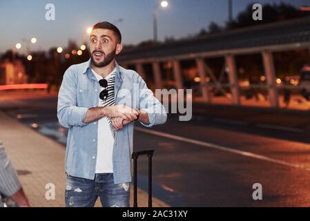 Feeling shocked. Man has meet a good old friend at evening near the road Stock Photo