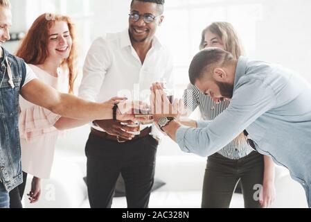 Short haired bearded guy decide to drink a lot today. Teammates drinking whiskey and laughing because of successful deal Stock Photo