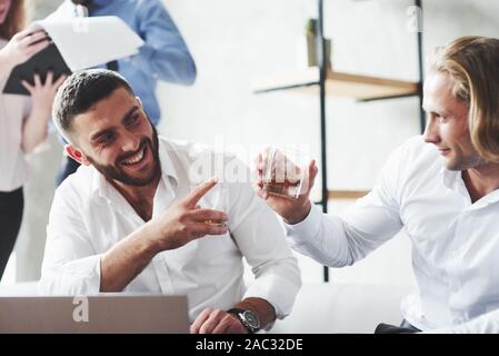 Your idea was great. Two colleagues celebrating good deal in their business by drinking alcohol Stock Photo