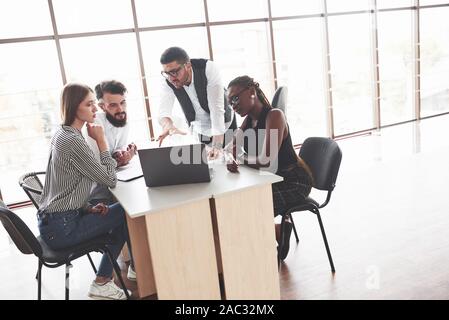 Team is listens to their manager. Group of freelancers working in the spacious office with big windows Stock Photo