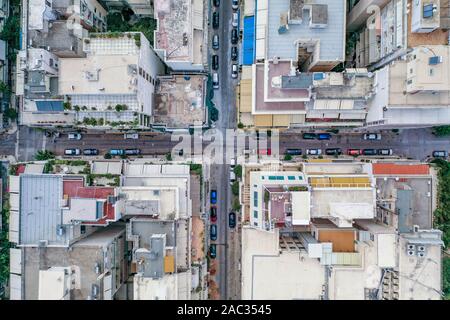 Overhead aerial drone shot of Athens street parked with cars near Lycabettus Hill in sunny summer