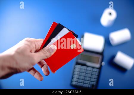 Easy payment concept. The person with credit cards in hand in front of the POS/cash register Stock Photo