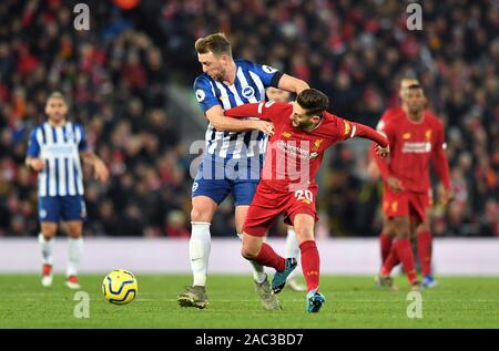 Brighton and Hove Albion's Dale Stephens (left) and Liverpool's Adam Lallana battle for the ball during the Premier League match at Anfield, Liverpool. Stock Photo