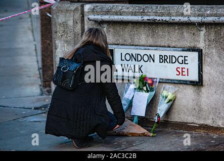 London, UK. 30th Nov, 2019. With the Police cordon still in place, with a heavy police presence, floral tributes were left at the corner of London Bridge by a member of the public in memory of those who were killed in yesterday's terrorist attack by Unman Khan, who was shot dead at the scene by police .Paul Quezada-Neiman/Alamy Live News Credit: Paul Quezada-Neiman/Alamy Live News Stock Photo