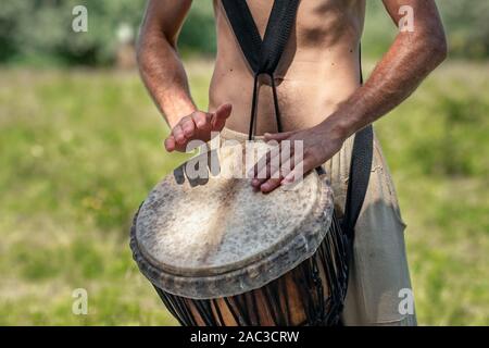 Unidentified caucasian man playing african djembe drum Stock Photo