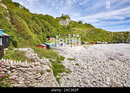 Secluded shingle beach and beach huts of Church Ope Cove on the coast of the Isle of Portland in Dorset UK Stock Photo