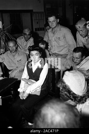 IVA TOGURI d'AQUINO (1916-2006) American-born Japanese broadcaster who shared the title  Tokyo Roase with several other women who broadcast Japanese propaganda during WW2. Seen here in September 1945 being questioned by American media correspondents. Photo: US Navy Stock Photo