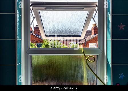 open bathroom plastic window with water pipe through it in england uk Stock Photo