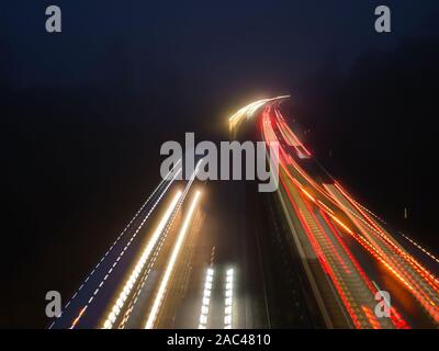 Highway at night with light stripes of moving cars Stock Photo