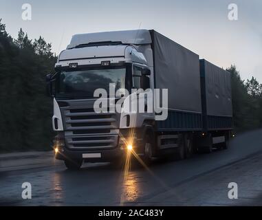 truck moves on country highway at night Stock Photo